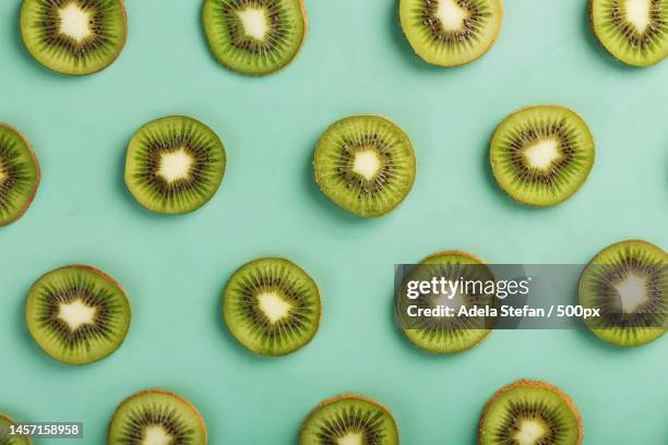 the patterns of the slices of kiwi fruit on green background as a continuous background,romania - kiwi fotografías e imágenes de stock