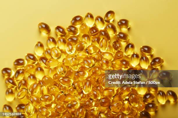 golden vitamin d3 capsules close-up in full screen,romania - fish oil stockfoto's en -beelden