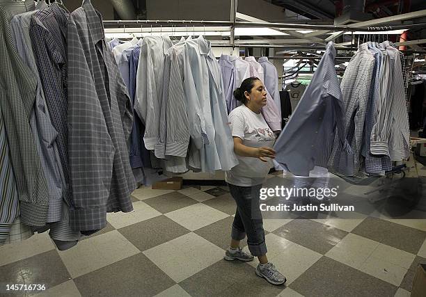 Worker at Maxwell the Cleaner sorts freshly pressed shirts on June 4, 2012 in San Rafael, California. Dry cleaning prices are on the rise as the cost...