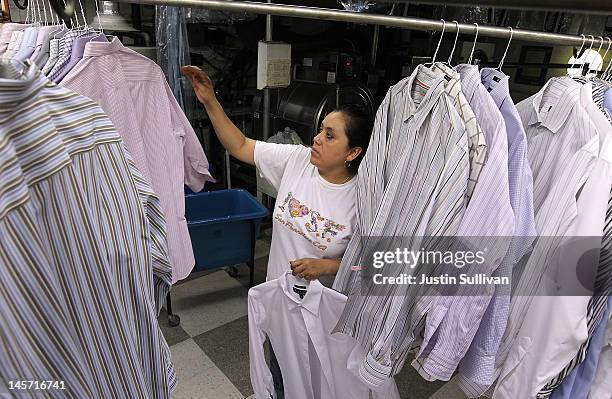 Worker at Maxwell the Cleaner sorts freshly pressed shirts on June 4, 2012 in San Rafael, California. Dry cleaning prices are on the rise as the cost...