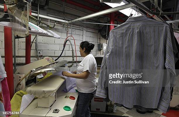 Worker at Maxwell the Cleaner uses a machine to press shirts on June 4, 2012 in San Rafael, California. Dry cleaning prices are on the rise as the...