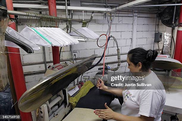 Worker at Maxwell the Cleaner uses a machine to press shirts on June 4, 2012 in San Rafael, California. Dry cleaning prices are on the rise as the...