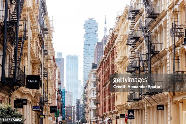 shopping street with luxury stores in soho, new york, usa - soho new york stockfoto's en -beelden