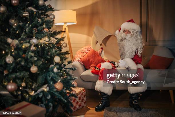 santa claus reading list of wishes - wishlist stock pictures, royalty-free photos & images