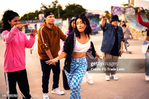 young woman dancing hip hop during street party with her friends - gangsta rappers stock pictures, royalty-free photos & images