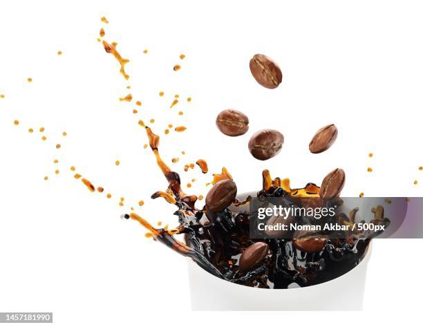 coffee beans splashing in coffee cup,pakistan - coffee drink splash stock pictures, royalty-free photos & images