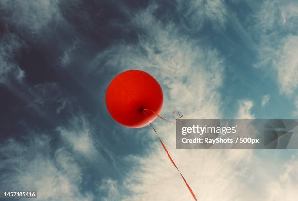 low angle view of red balloons flying against sky,kish island,kish,iran - helium stock-fotos und bilder