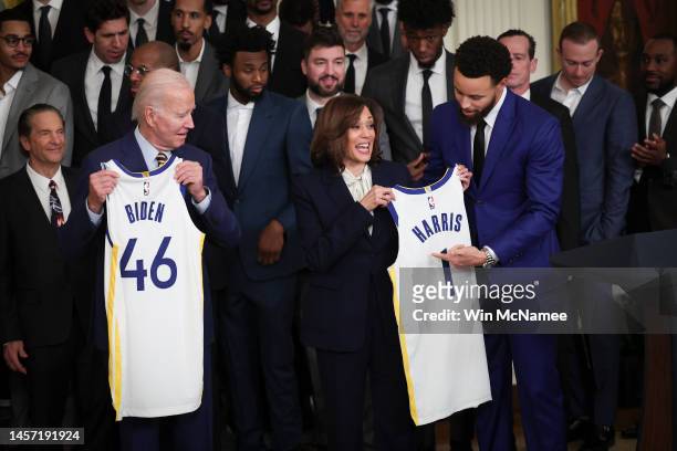 Golden State Warriors star Steph Curry presents U.S. Vice President Kamala Harris with a jersey bearing as President Joe Biden looks on January 17,...