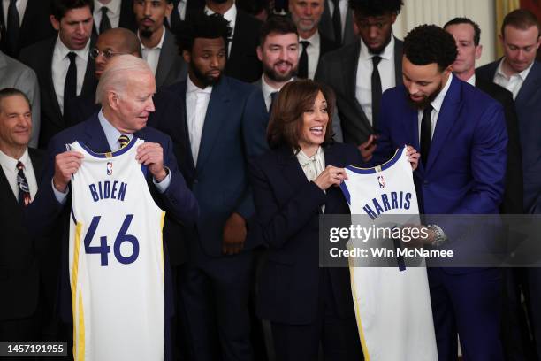 Golden State Warriors star Steph Curry presents U.S. Vice President Kamala Harris with a jersey bearing as President Joe Biden looks on January 17,...