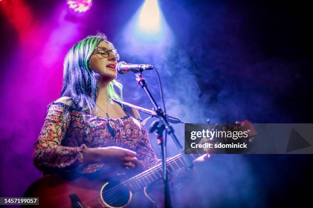 your woman singer and guitarist performing live concert - guitar stage stock pictures, royalty-free photos & images