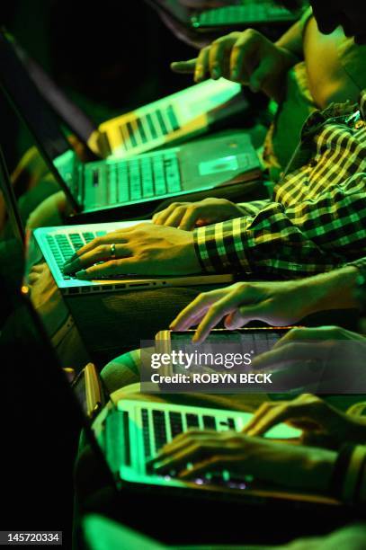 Attendees use their computers and tablets as they await the start of the Microsoft Xbox E3 2012 media briefing in Los Angeles on June 4, 2012. The...