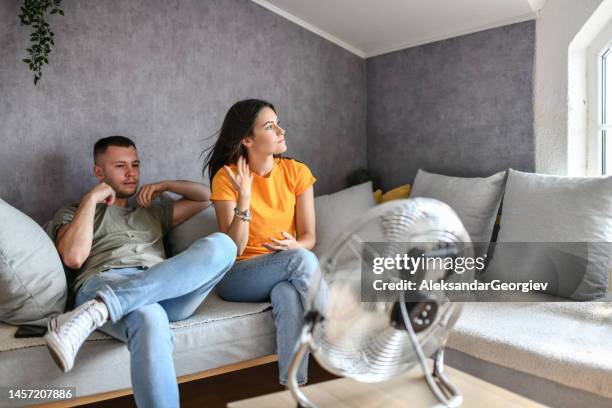 hot summer days making couple use fan at home - ventilador elétrico imagens e fotografias de stock