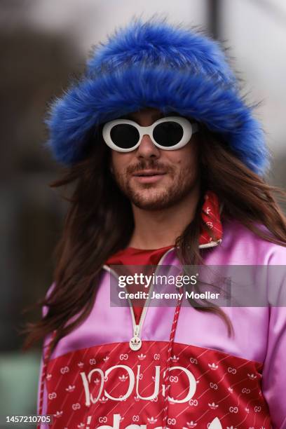 Riccardo Simonetti seen wearing Gucci x Adidas blue sneaker & Gucci x Adidas pink red and blue basketball jacket, Carhartt denim blue jeans, Acne...