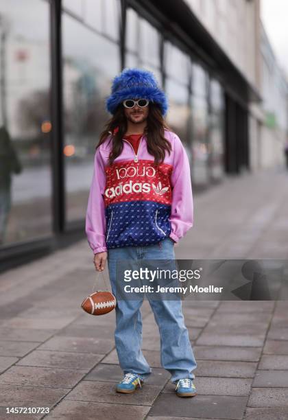 Riccardo Simonetti seen wearing Gucci x Adidas blue sneaker & Gucci x Adidas pink red and blue basketball jacket, Carhartt denim blue jeans, Acne...
