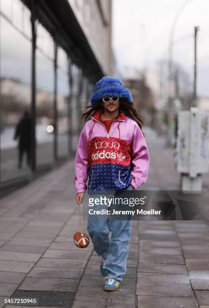 Riccardo Simonetti seen wearing Gucci x Adidas blue sneaker & Gucci x Adidas pink red and blue basketball jacket, Carhartt denim blue jeans, Acne...