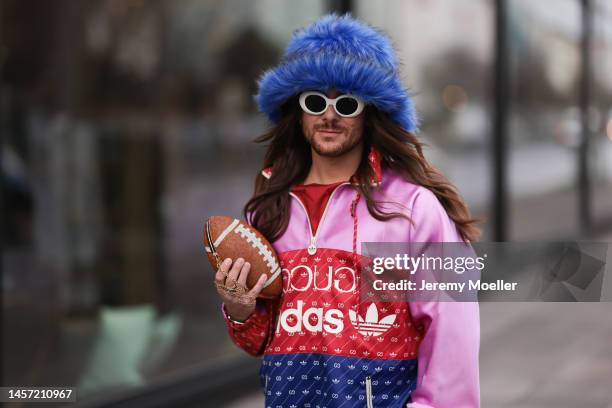 Riccardo Simonetti seen wearing Gucci x Adidas blue sneaker & Gucci x Adidas pink red and blue basketball jacket, Carhartt denim blue jeans, Acne...