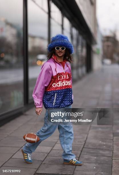 Riccardo Simonetti seen wearing Gucci x Adidas blue sneaker & Gucci x Adidas pink red and blue basketball jacket, Carhartt denim blue jeans, Acne...