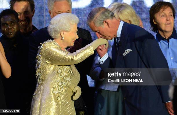 Prince Charles kisses the hand of Britain's Queen Elizabeth II on stage as well as British singer Paul McCartney looks on after the Jubilee concert...
