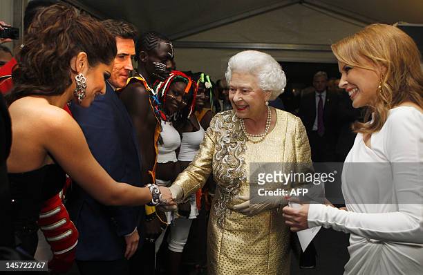 Queen Elizabeth II greets British singer Cheryl Cole and Australian singer Kylie Minogue backstage during the Diamond Jubilee Concert outside...