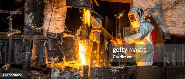 male worker in factory operating with hot molten metal material - molten stock pictures, royalty-free photos & images