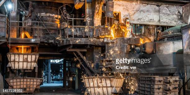 male worker in factory operating with hot molten metal materia - materia stock pictures, royalty-free photos & images