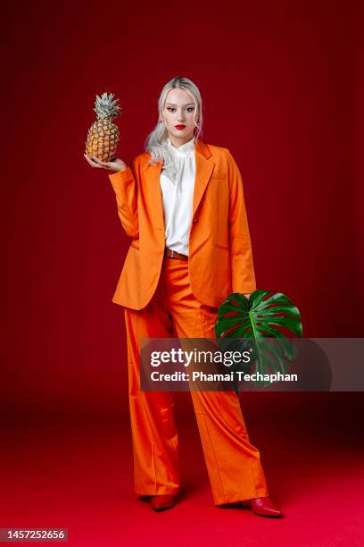 fashionable woman wearing orange suit - fashion food stock pictures, royalty-free photos & images