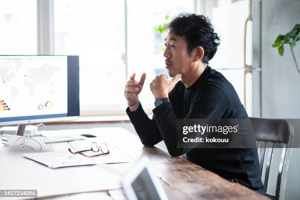 one asian man presenting his ideas at a conference - japanese ethnicity stock pictures, royalty-free photos & images