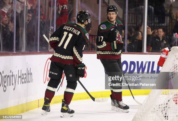 Nick Bjugstad of the Arizona Coyotes celebrates with Dylan Guenther after scoring a goal against the Detroit Red Wings during the second period of...