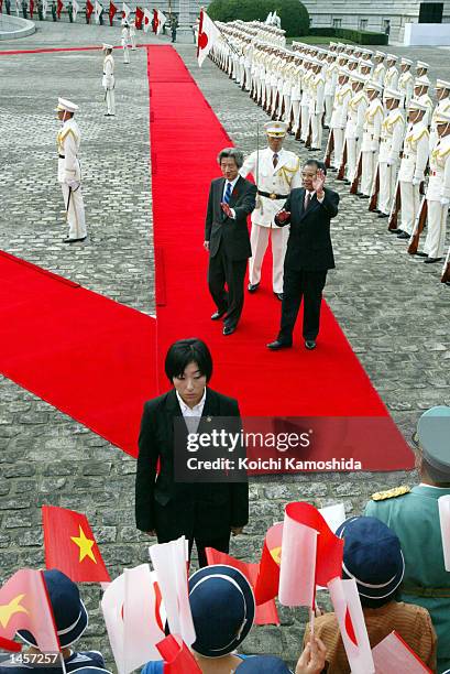 Vietnamese Communist Party General Secretary Nong Duc Manh and Japanese Prime Minister Junichiro Koizumi are greeted by supporters during a welcome...