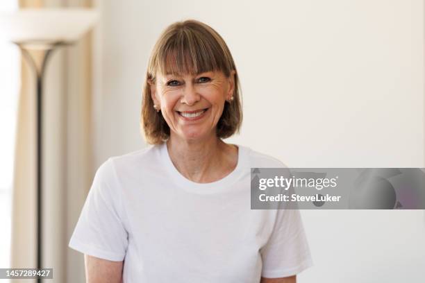 happy laughing senior woman at home - woman white t shirt stock pictures, royalty-free photos & images