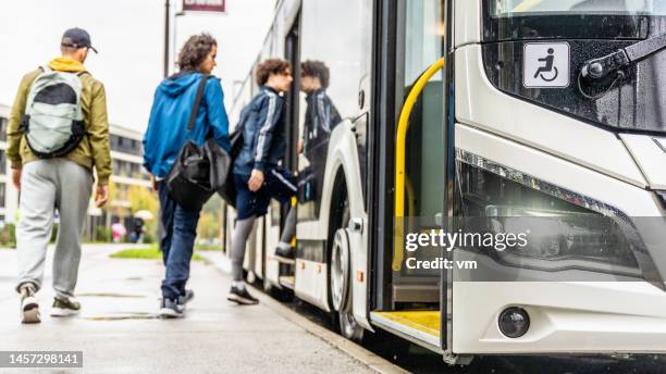 diverse passengers boarding city bus, wide shot - autobus stock pictures, royalty-free photos & images