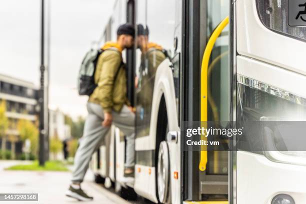 man boarding bus, accent sélectif sur le côté pare-chocs des transports en commun - bus photos et images de collection