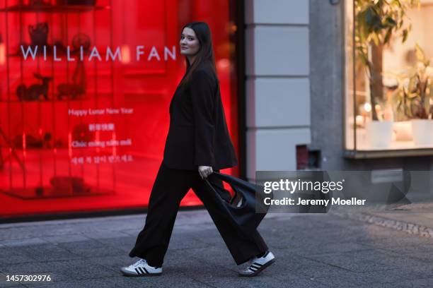 Annika Rogge seen wearing before the William Fan show Adidas samba sneaker, black blazer, black shirt, wide black trousers and a black big bag during...