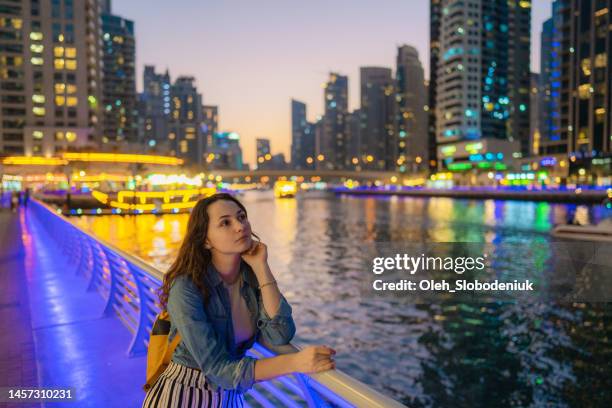 woman walking in dubai marina at sunset - dubai marina stock pictures, royalty-free photos & images