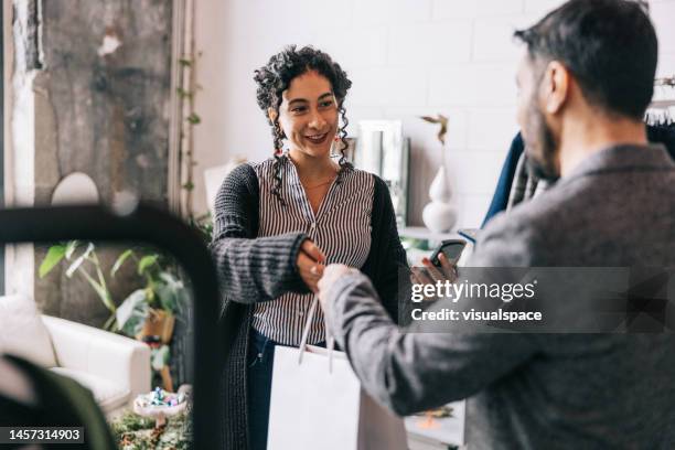 un indien effectuant un paiement mobile dans une boutique de petite entreprise - consumers retail photos et images de collection