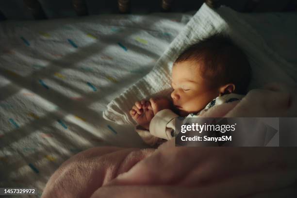 sleeping newborn baby girl - cot stock pictures, royalty-free photos & images