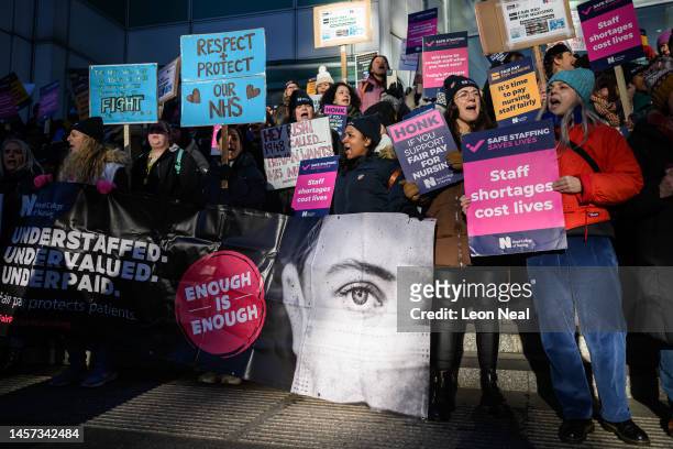 Nursing staff and supporters chant and wave placards as they protest outside University College Hospital during a day of strikes, on January 18, 2023...