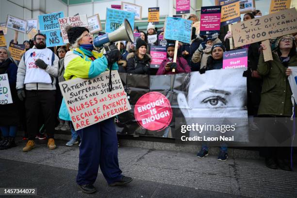 Nursing staff and supporters chant and wave placards as they protest outside University College Hospital during a day of strikes, on January 18, 2023...