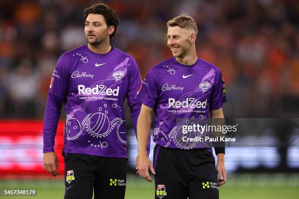 Tim David and Riley Meredith of the Hurricanes looks on during the Men's Big Bash League match between the Perth Scorchers and the Hobart Hurricanes...