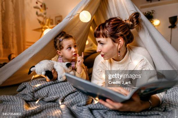 reading a book under the illuminated tent. - players to watch stock-fotos und bilder