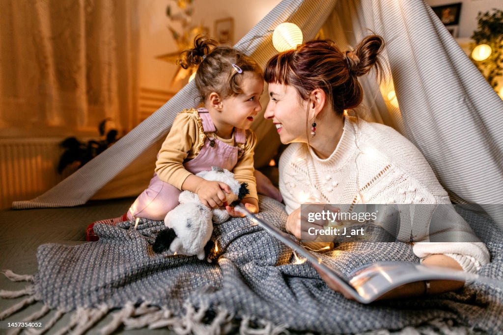 Reading a book under the illuminated tent.