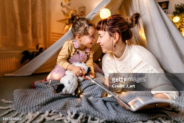 reading a book under the illuminated tent. - toddler fotografías e imágenes de stock
