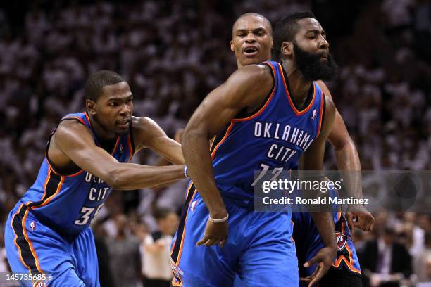 Kevin Durant and Russell Westbrook of the Oklahoma City Thunder celebrate with James Harden after he hit a three pointer late in the game against the...