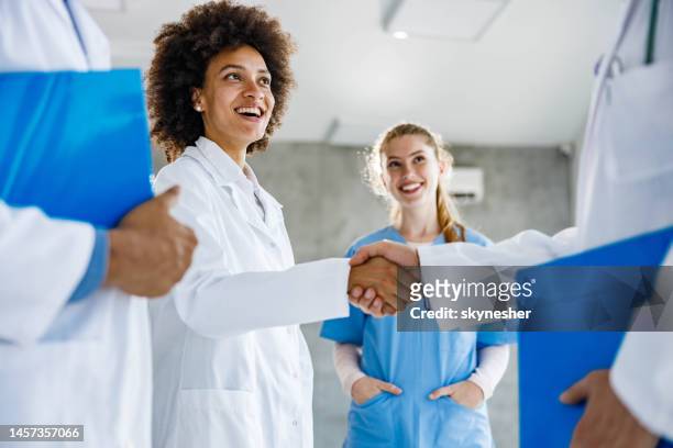 successful deal between doctors! - handshake doctor stock pictures, royalty-free photos & images
