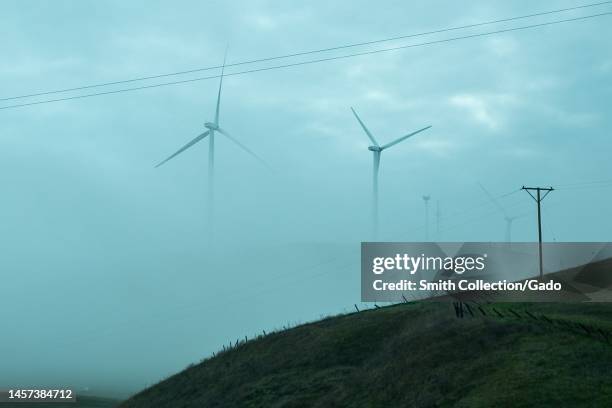 Wind turbines emerge from fog at Altamont Pass, Livermore, California, December 26, 2022.