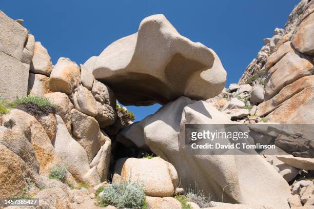 huge granite boulders clinging to hillside above the strait of bonifacio, capo testa, santa teresa di gallura, sassari, sardinia, italy - overhangend stockfoto's en -beelden