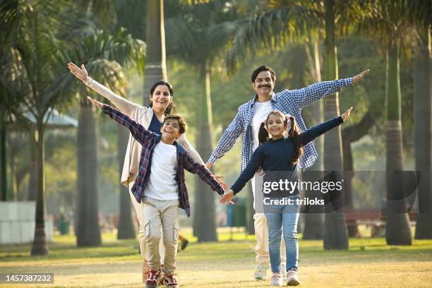 happy parents having fun with children at park - mum dad daughter stock pictures, royalty-free photos & images