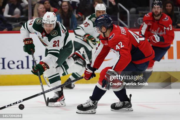 Brandon Duhaime of the Minnesota Wild shoots in front of Martin Fehervary of the Washington Capitals during the third period at Capital One Arena on...