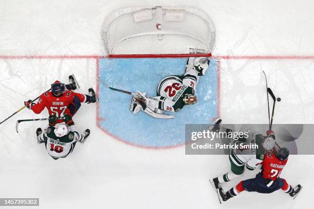 Nic Dowd of the Washington Capitals and Jon Merrill of the Minnesota Wild battle for the puck in front of the goal during at Capital One Arena on...