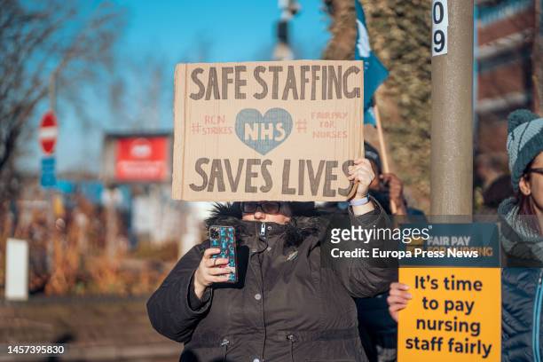 Healthcare worker holds a placard during a rally outside St George's University of London, January 18 in London, United Kingdom. The walkouts today...